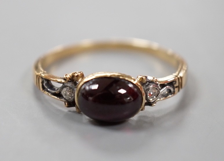 A 19th century yellow metal and single stone cabochon garnet set ring, with diamond chip set shoulders, size M, gross weight1.9 grams.